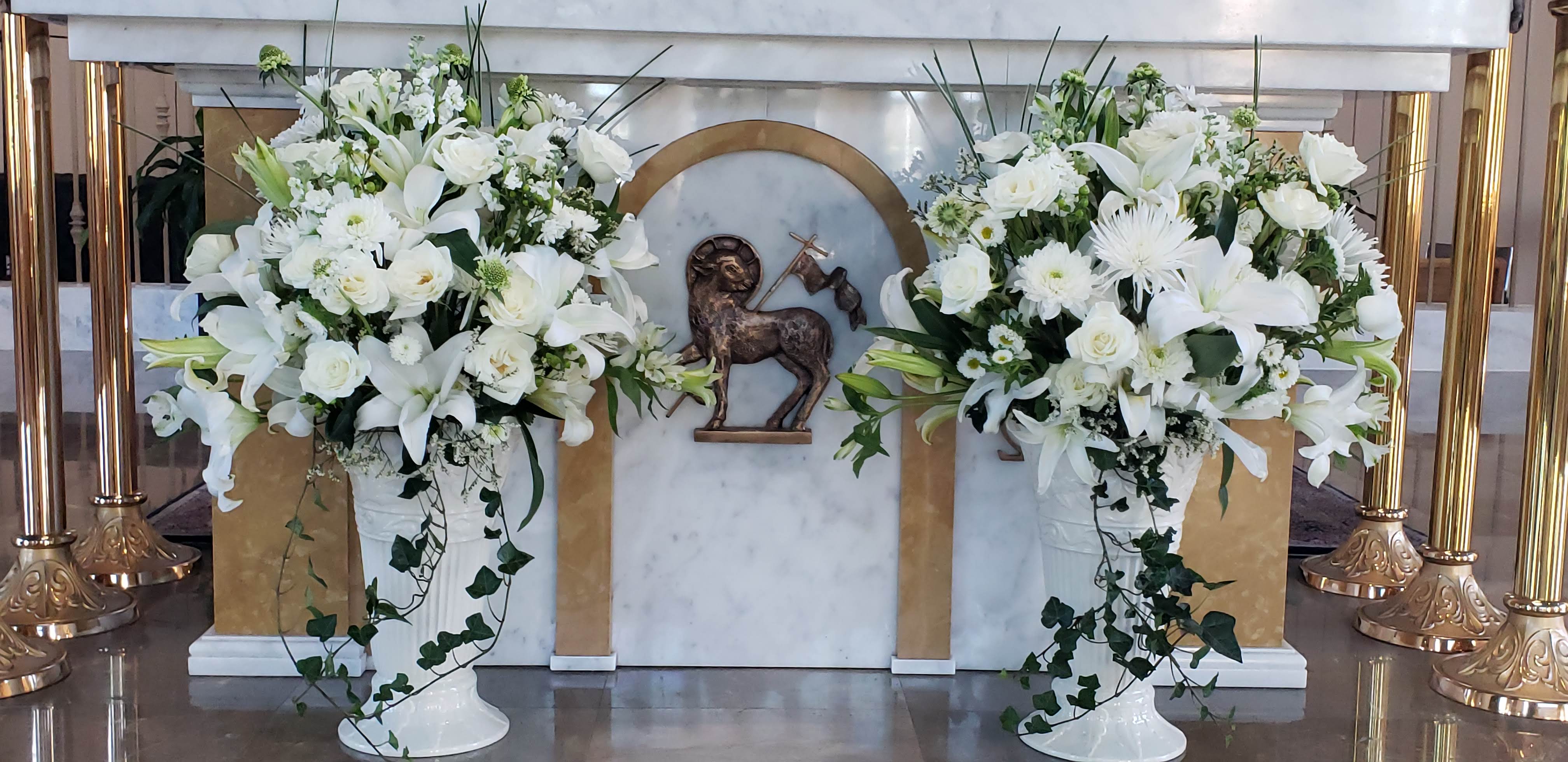 White Lilies, White Roses, White Spider Mums, White Alstroemeria, Green Scabiosa Pods, Ivy Vines, Baby’s Breath (Gypsophila), Bear Grass (Xerophyllum tenax) & White Stock (Matthiola incana)